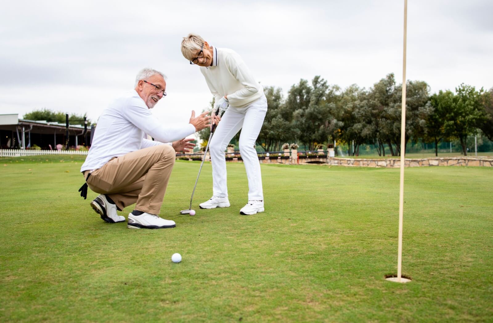 A happy senior couple enjoys an afternoon playing golf together.