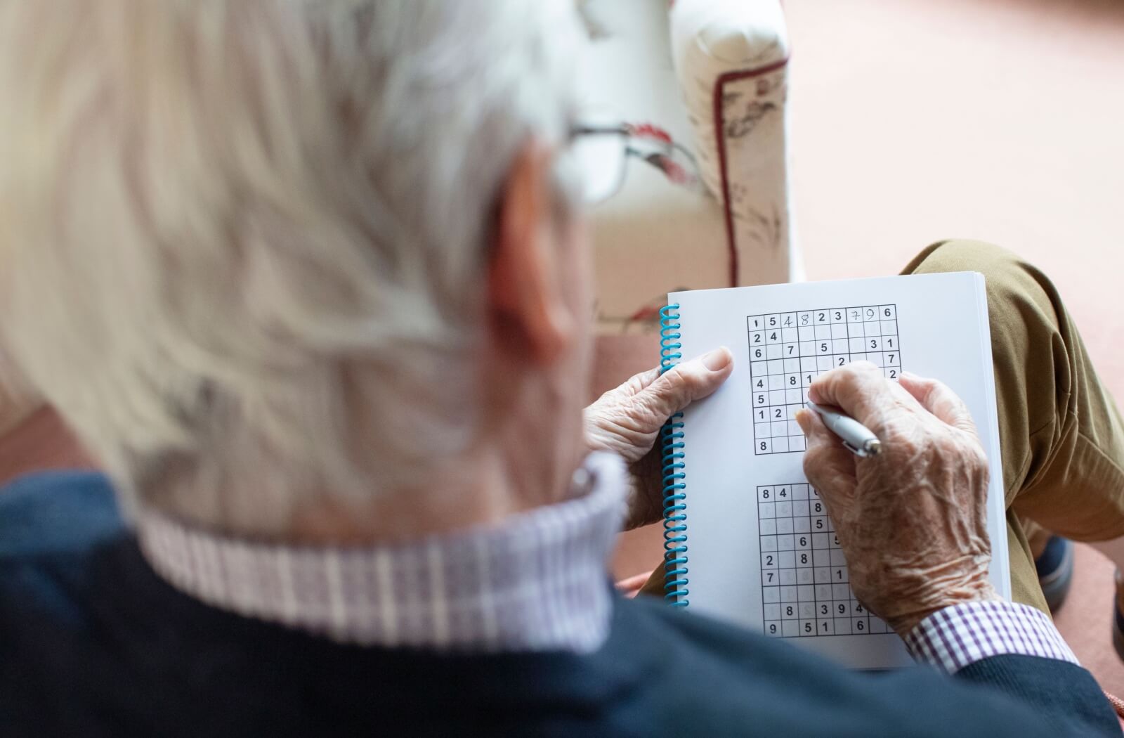 A senior gets to work on a Sudoku puzzle.